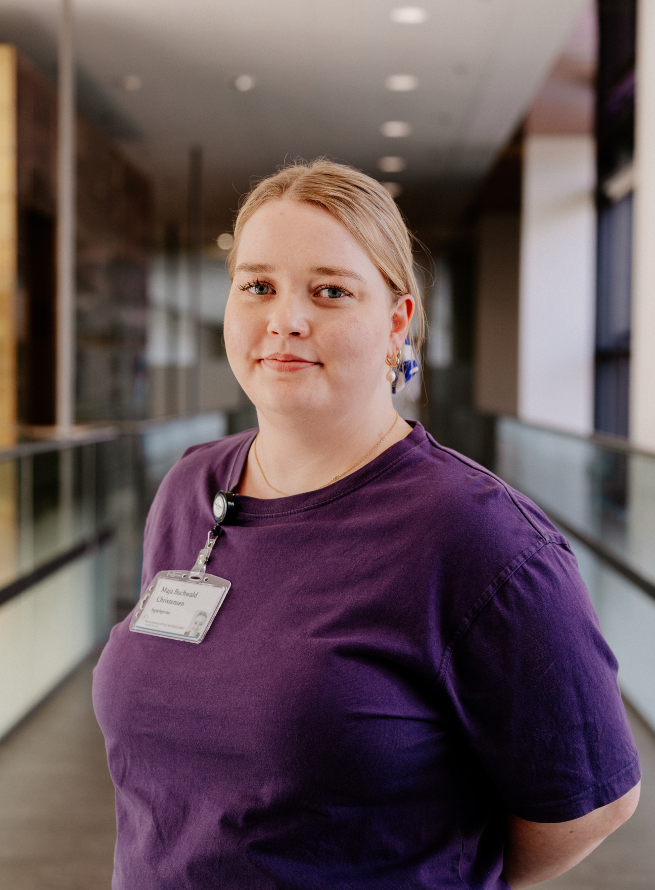 Caregiver wearing a purple shirt in a hallway