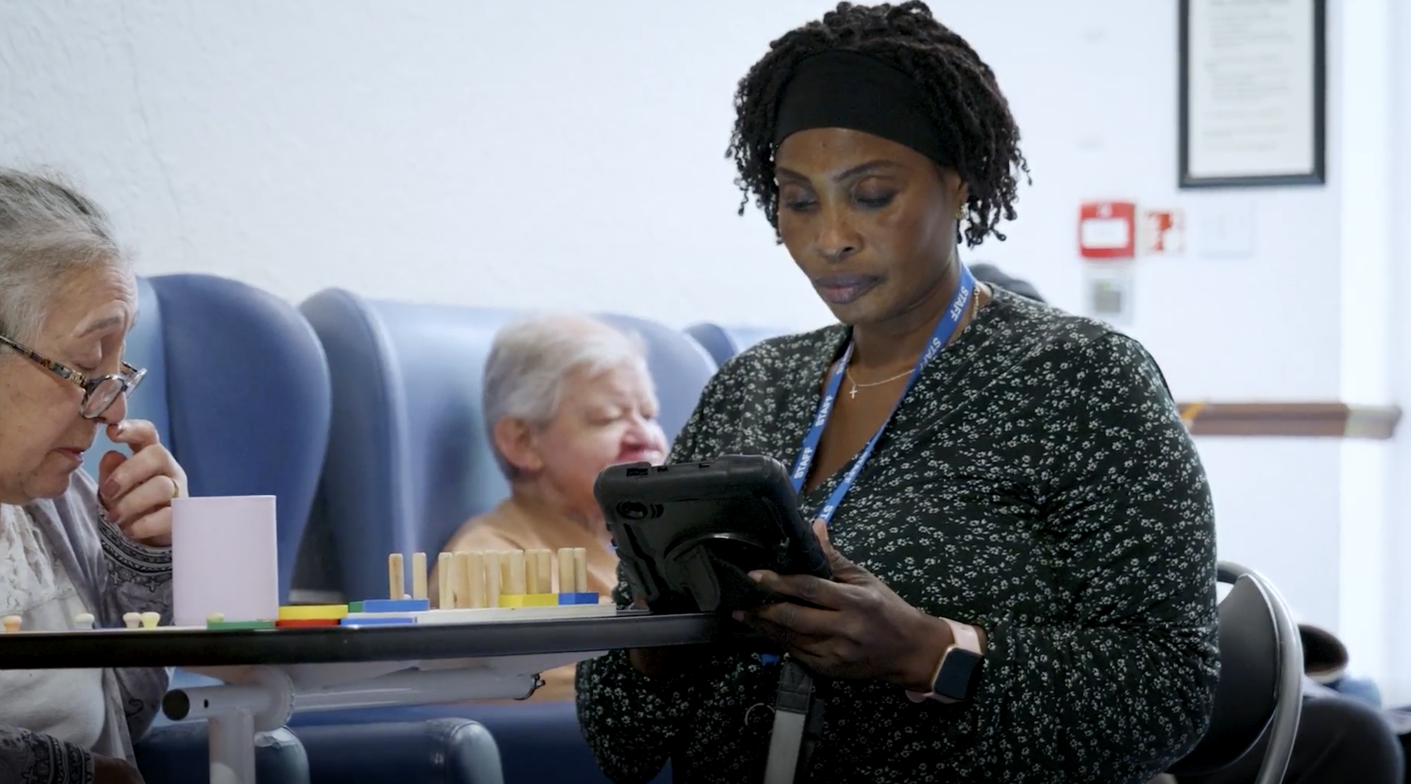 Care worker using Nourish on a tablet with residents